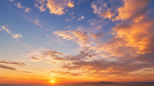 オレンジ色の夕日と茜雲が広がる夕焼け空背景