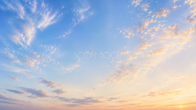 淡い夕焼け雲が広がる優しい空の背景
